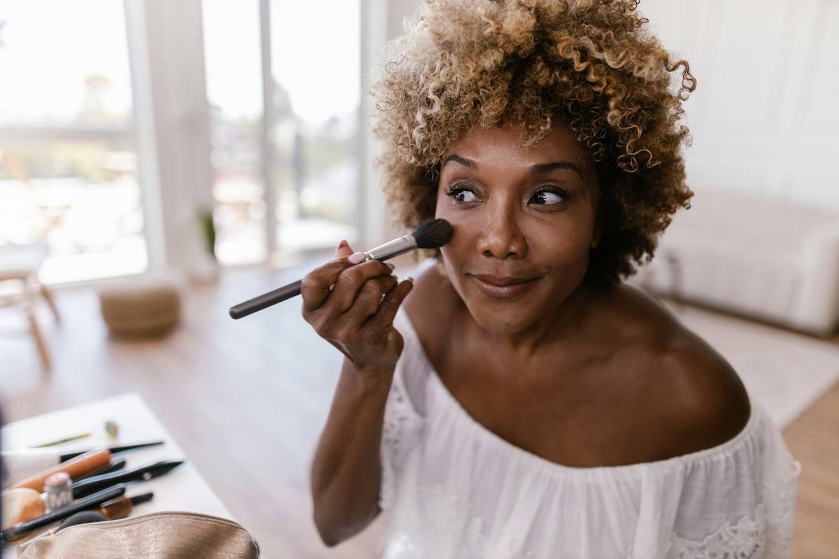 Side-by-side comparison showing same makeup under warm indoor light (left) vs. 5000K daylight-balanced beauty essentials light (right). Right side reveals true skin texture, accurate undertones, and visible contouring.