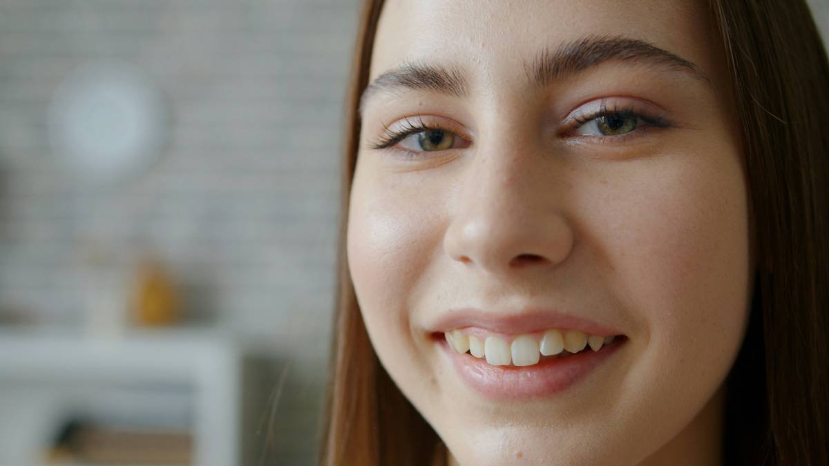 Side-by-side photo showing a model's face lit by warm bathroom bulb (left) vs. 5500K application enhancement light (right). Left shows orange cast and missed under-eye concealer; right reveals true skin tone and precise blending.